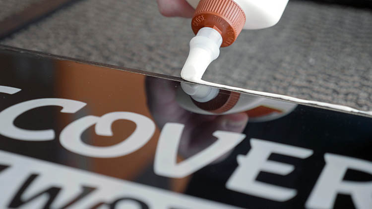 Applying glue to the exposed front edges of the sign box.